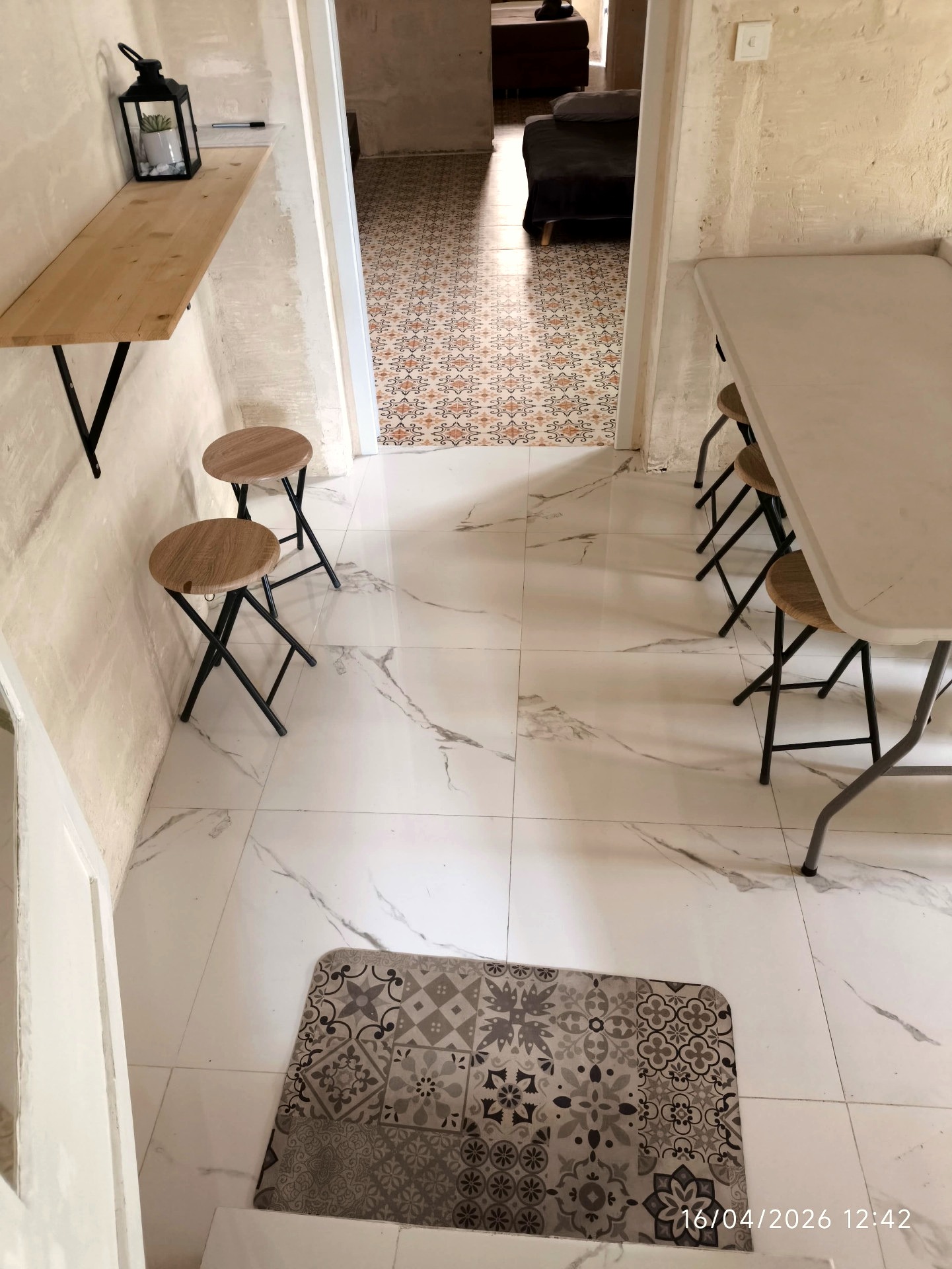 Compact dining and kitchen area with marble floors and warm limestone walls